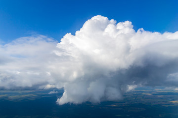 Closeup of one single big white cloud on the right side, in the clear deep blue sky, on a sunny day