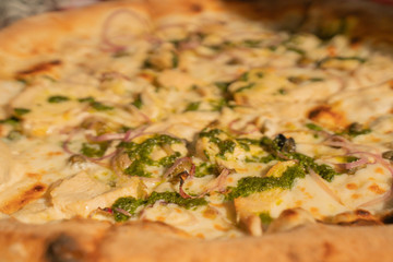 Fresh sunny pizza with cheese and spinage on the table at home