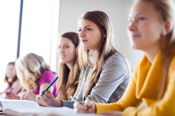 College students in classroom during class, paying attention to the teacher (color toned image)