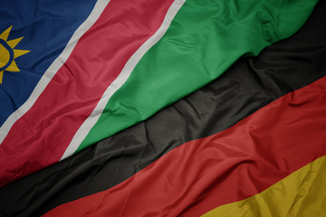 waving colorful flag of germany and national flag of namibia.