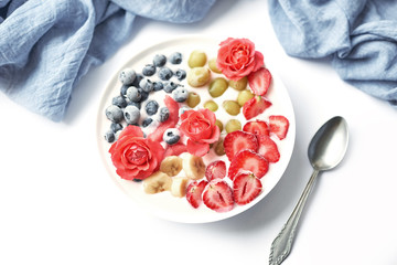 plate with vegan slices of frozen fruits: arbuk, blueberries, blueberries, banana with yogurt