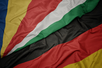 waving colorful flag of germany and national flag of seychelles.