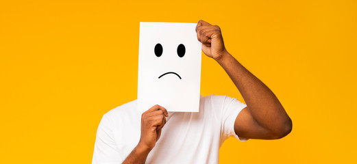 Black man holding paper with sad face