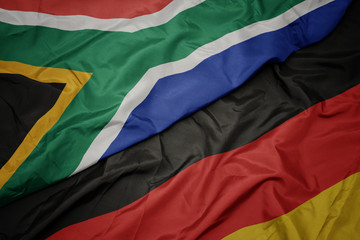 waving colorful flag of germany and national flag of south africa.