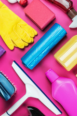 various products for cleaning the house on a pink background.