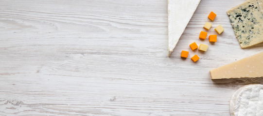 Set of various cheese on a white wooden surface, top view. Copy space. Food for wine. Flat lay, from above, overhead.