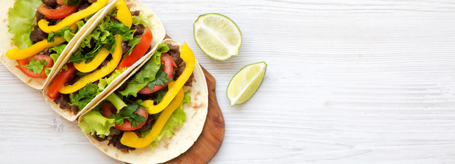 Beef tacos with salad and pepper on a white wooden backgrund, top view. Flat lay, overhead, from...