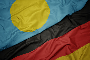 waving colorful flag of germany and national flag of Palau.