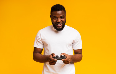 Happy african american man playing video games with joystick