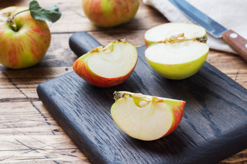 Red apples on a wooden table. Apples cut into slices. Copy space.