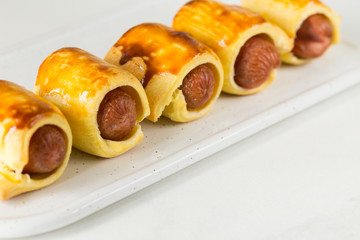 Pastry wrapped sausage rolls, fried sausage pies in dough. Junk food