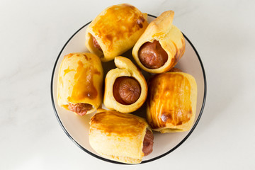 Pastry wrapped sausage rolls, fried sausage pies in dough. Junk food