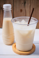 Bottle of soy milk and soybean on wooden table