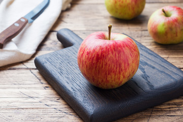 Red apples on a wooden table. Apples cut into slices. Copy space.