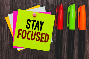 Conceptual hand writing showing Stay Focused. Business photo showcasing Be attentive Concentrate Prioritize the task Avoid distractions Paper notes Communicate ideas Markers Wooden background