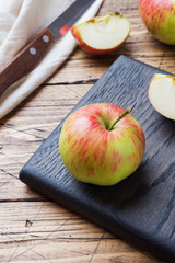 Red apples on a wooden table. Apples cut into slices. Copy space.