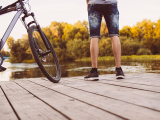 Obraz premium Cyclist on a wooden bridge and the last days of the outgoing summer