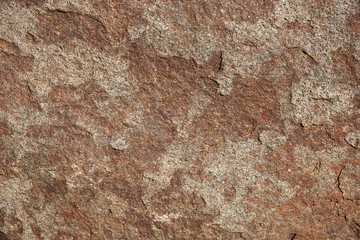 Naklejka premium A fragment of the surface of a stone made of granite. Background, texture