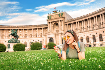 Happy asian girl on a grass lawn playing with toy airplane, as symbol of travelling and transportation for tourists.