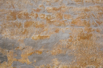 Texture of gray brick wall with gold scuffs