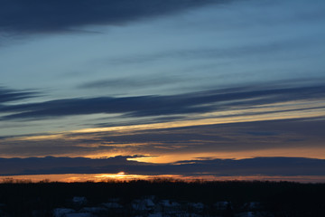 Fototapeta na wymiar Sunset with dark blue clouds in the winter evening. Dramatic light.