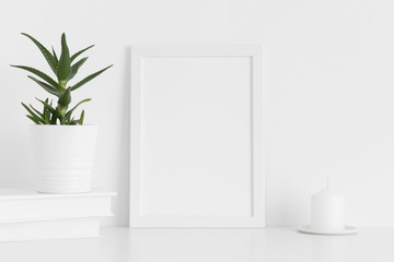 White frame mockup with workspace accessories and a aloe vera on a white table.Portrait orientation.