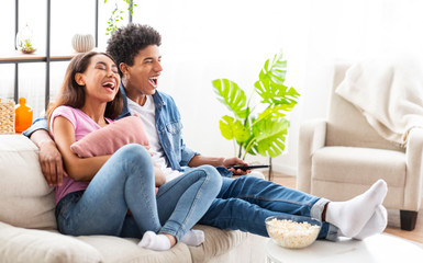 Watching Comedy Movie. Loving Teenage Couple Resting On Sofa