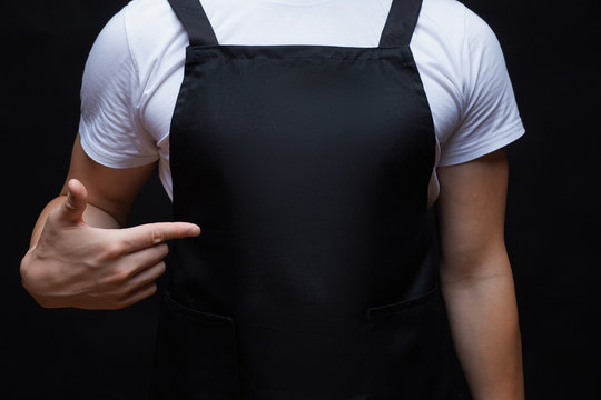 Closeup strong man wearing black apron.