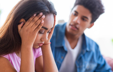 Black teen guy comforting his upset female friend