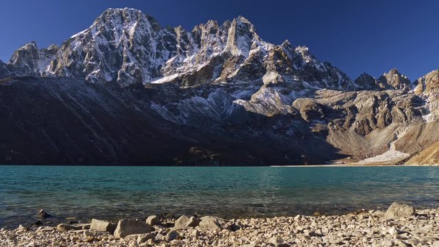 Clean transparent water of Gokyo Lake high up in Himalaya, Nepal. Snowy Mount Gokyo Ri is in the background