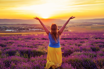 Girl in a lavender field at sunset. Sunny summer evening in Crimea.