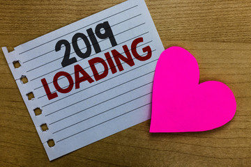 Conceptual hand writing showing 2019 Loading. Business photo showcasing Advertising the upcoming year Forecasting the future event Notebook paper Romantic ideas heart feelings Wooden table