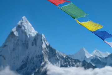 Colorful landscape with high Himalayan mountain Ama Dablam and Prayer colorful flags on foreground