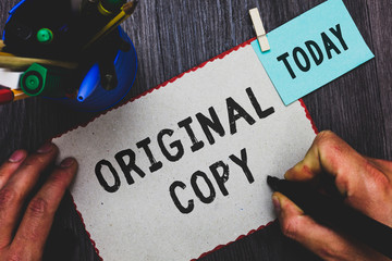 Conceptual hand writing showing Original Copy. Business photo text Main Script Unprinted Branded Patented Master List Man holding marker paper clothespin reminder cup marker wood table