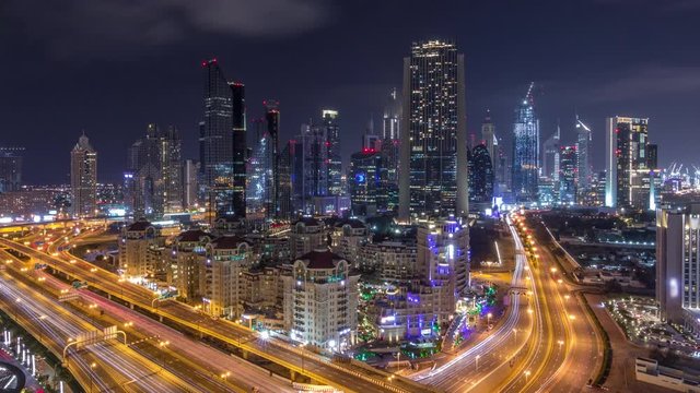 Aerial view to downtown and financial district in Dubai during all night timelapse, lights swithing off. United Arab Emirates with illuminated skyscrapers and highways.