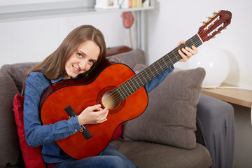 Fototapeta premium woman play guitar at home