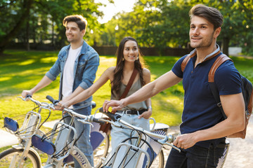 Obraz premium Group of happy friends riding bicycles at the park