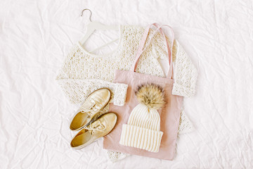 Knitted white sweater with hat, shoes and tote bag. Autumn/winter fashion clothes collage on white background. Top view flat lay.