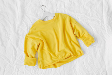 Yellow sweater . Autumn  clothes  on white background. Top view flat lay.