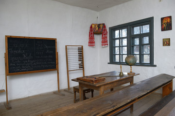 Classroom in Ukrainian school of 19 century: blackboard, teacher’s table with a globe, abacus, school desks