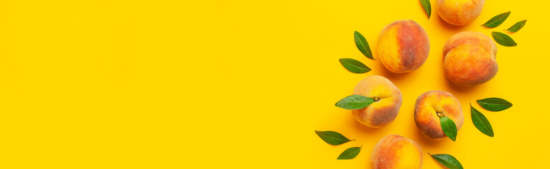 Flat lay composition with peaches. Ripe juicy peaches with green leaves on yellow background. Flat lay, top view, copy space. Fresh organic fruit, vegan food. Harvest concept