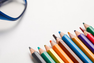 spectacles and color pencil on white background  