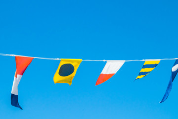 Nautical flags on the ship against blue sky