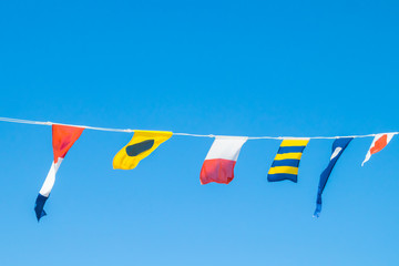 Nautical flags on the ship against blue sky