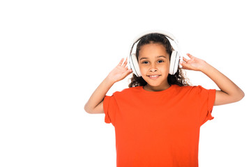 cheerful african american child listening music in headphones isolated on white