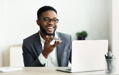 African American businessman using voice assistant on smartphone