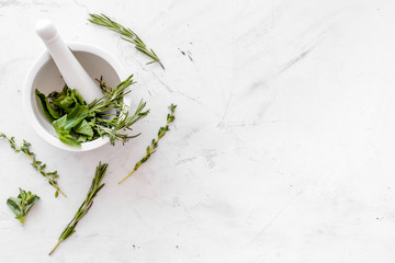 Alternative medicine with medicinal herbs on white marble background top view mock up