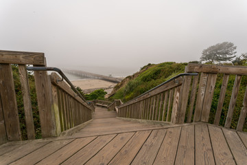 View of Pier With Heavy Fog From Top of Wooden Stairs