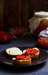 ajvar, appetizer of baked peppers on the table, bread with ajvar, toast with ajvar, balkan appetizer of baked peppers, vertical, space for your text