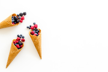 Summer breakfast with fresh berries in waffle cones on white background top view mockup